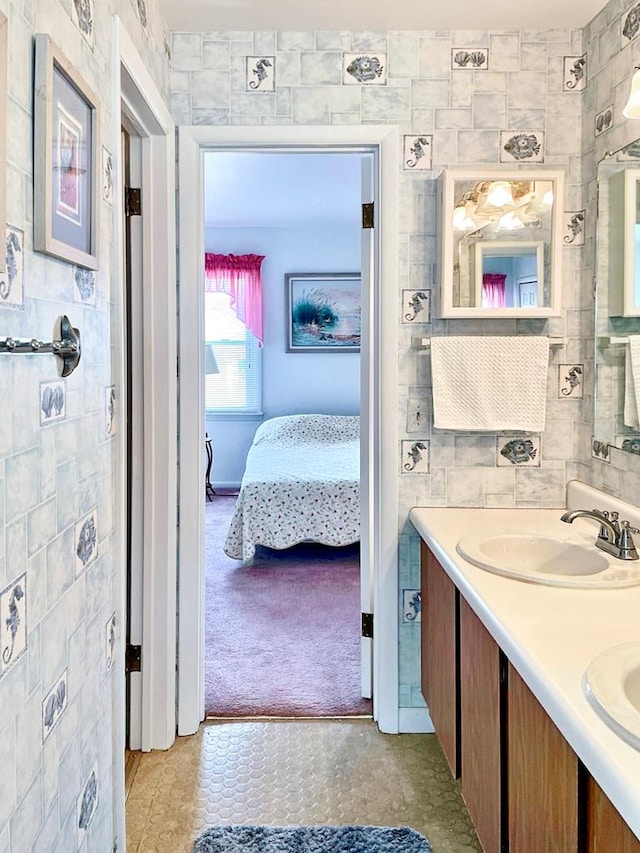 bathroom featuring tile patterned flooring, vanity, and tile walls