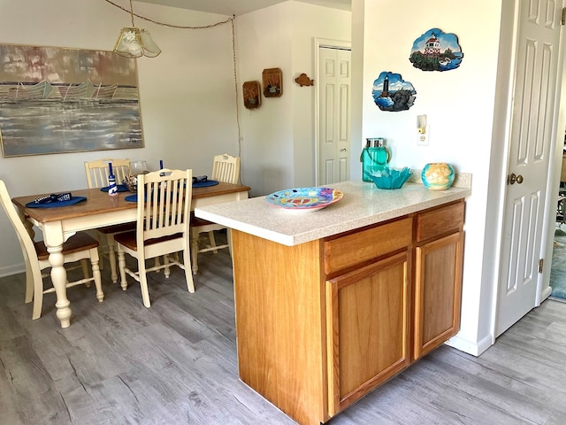 kitchen with pendant lighting and light hardwood / wood-style floors