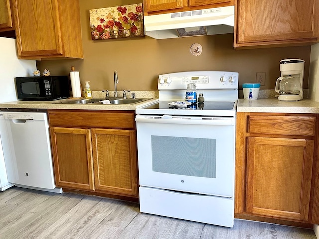 kitchen with sink, white appliances, and light wood-type flooring