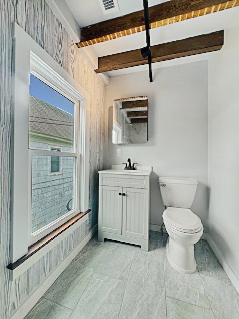 4169 Main St, Chincoteague, VA 23336 - half bathroom featuring toilet, beam ceiling, vanity, and baseboards
