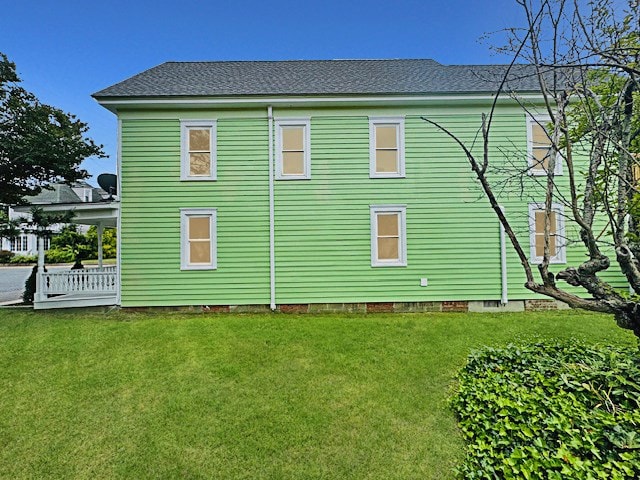 4169 Main St, Chincoteague, VA 23336 - view of property exterior featuring a lawn and roof with shingles