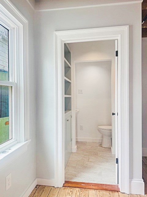 4169 Main St, Chincoteague, VA 23336 - bathroom featuring toilet, wood finished floors, baseboards, and healthy amount of natural light
