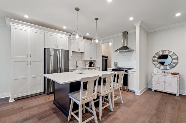 199 Old Course Loop, Cape Charles, VA 23310 - kitchen with wall chimney range hood, light countertops, backsplash, appliances with stainless steel finishes, and recessed lighting