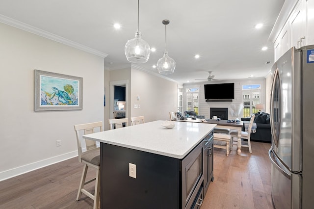 199 Old Course Loop, Cape Charles, VA 23310 - kitchen with wood finished floors, a breakfast bar area, ceiling fan, freestanding refrigerator, and recessed lighting