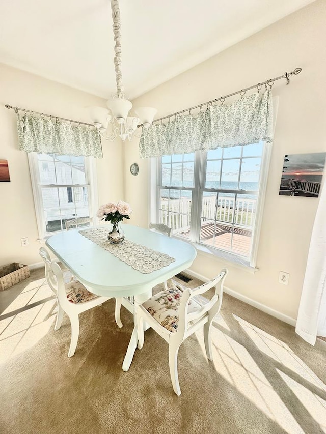 15259 Russell Dr, Onancock, VA 23417 - dining room featuring carpet floors, a chandelier, and a water view