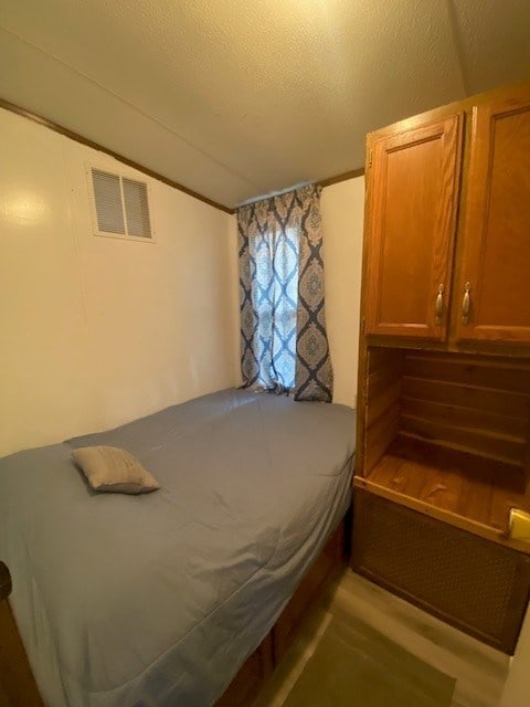 bedroom with vaulted ceiling and a textured ceiling