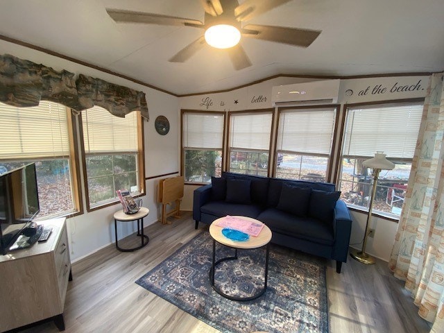 living room with ceiling fan, lofted ceiling, light hardwood / wood-style floors, and an AC wall unit