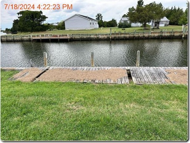 view of dock featuring a yard and a water view