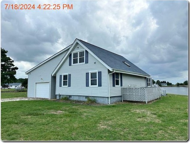 back of house featuring a lawn and a water view