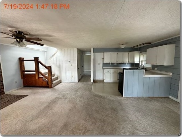 kitchen with ceiling fan, sink, kitchen peninsula, a textured ceiling, and white cabinets