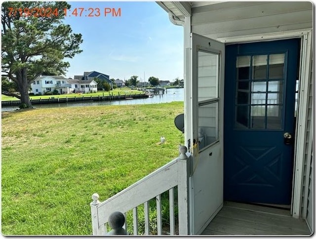 doorway to property featuring a lawn and a water view