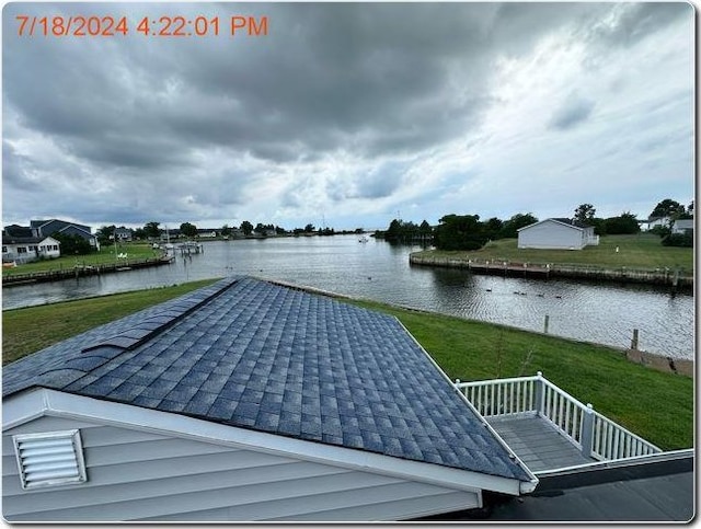 view of dock with a water view and a yard