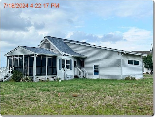 back of property featuring a lawn and a sunroom