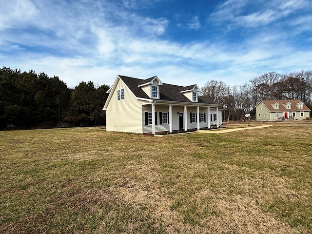 cape cod house featuring covered porch and a front yard