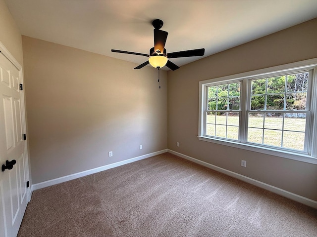 unfurnished room with baseboards, light colored carpet, and a ceiling fan