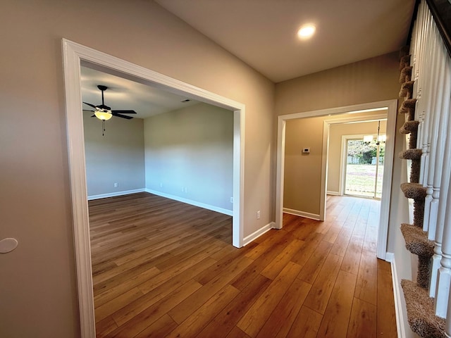 hall with baseboards and wood-type flooring