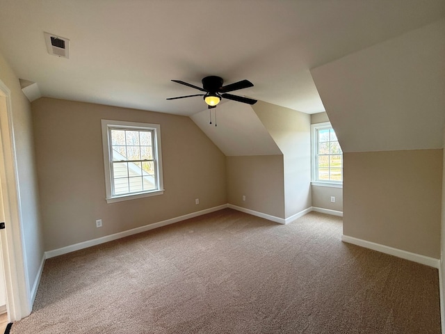 additional living space with visible vents, ceiling fan, baseboards, vaulted ceiling, and carpet floors