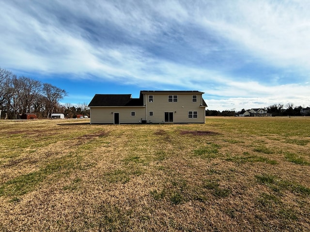 rear view of house featuring a lawn