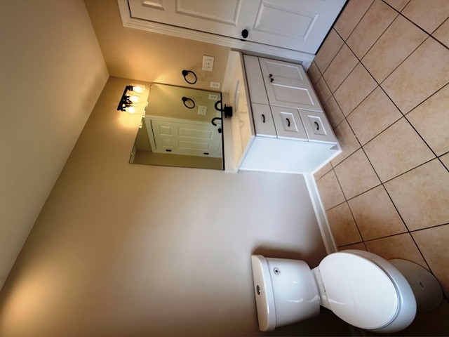 bathroom with toilet and tile walls