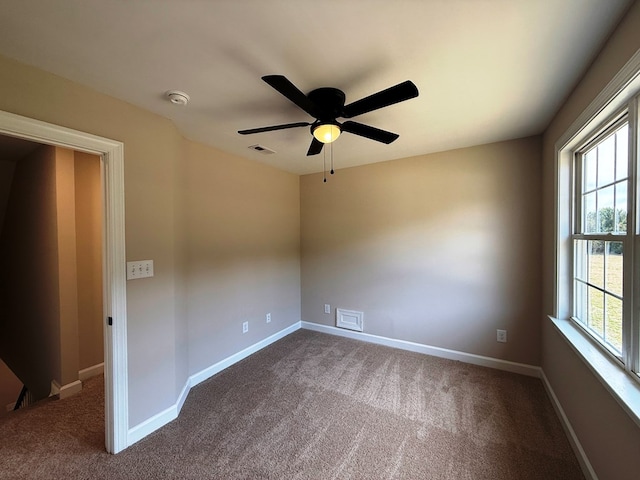 unfurnished room featuring baseboards, visible vents, and dark colored carpet