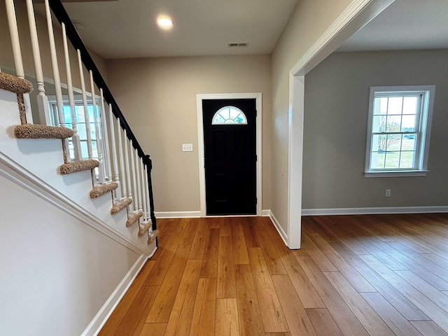 entryway featuring light wood finished floors, visible vents, stairs, and baseboards