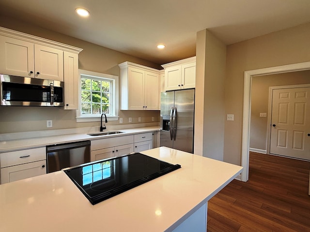 kitchen featuring dark wood-type flooring, recessed lighting, appliances with stainless steel finishes, white cabinetry, and a sink