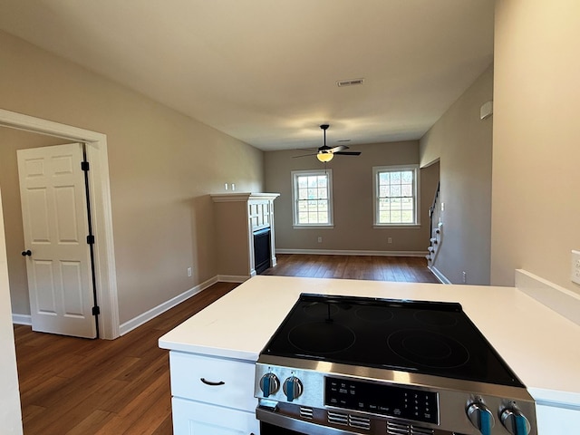 kitchen with a ceiling fan, stainless steel electric range, dark wood-style flooring, and a fireplace