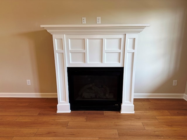 details with a fireplace, baseboards, and wood finished floors