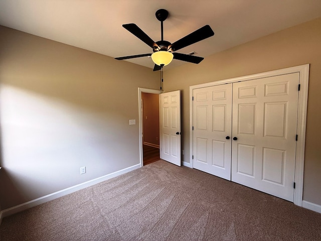 unfurnished bedroom with carpet flooring, a ceiling fan, baseboards, and a closet