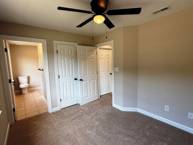 unfurnished bedroom featuring visible vents, carpet floors, baseboards, and a ceiling fan