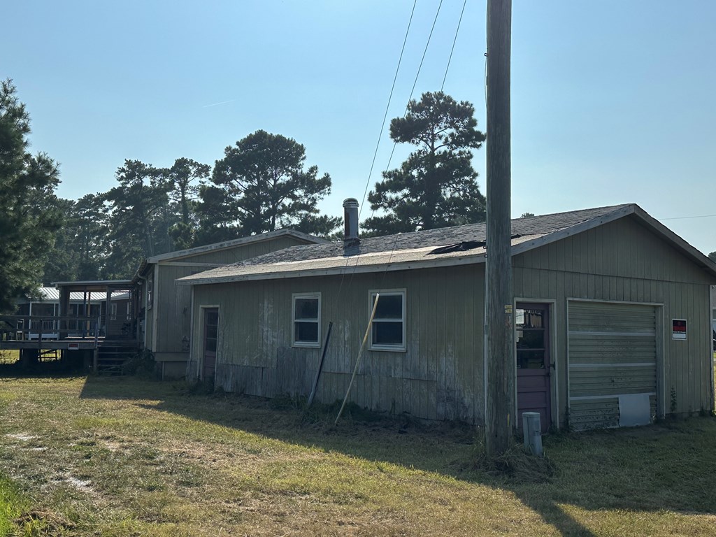 view of side of home featuring a wooden deck and a lawn