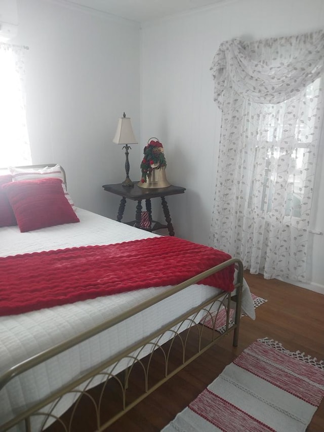 bedroom featuring dark hardwood / wood-style flooring and a wall mounted AC