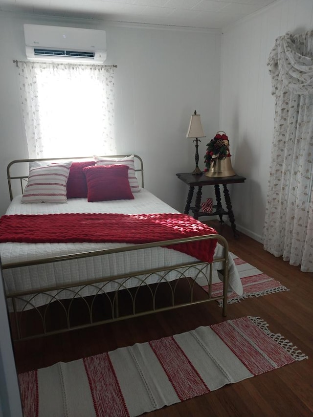 bedroom with a wall mounted air conditioner, dark wood-type flooring, and ornamental molding