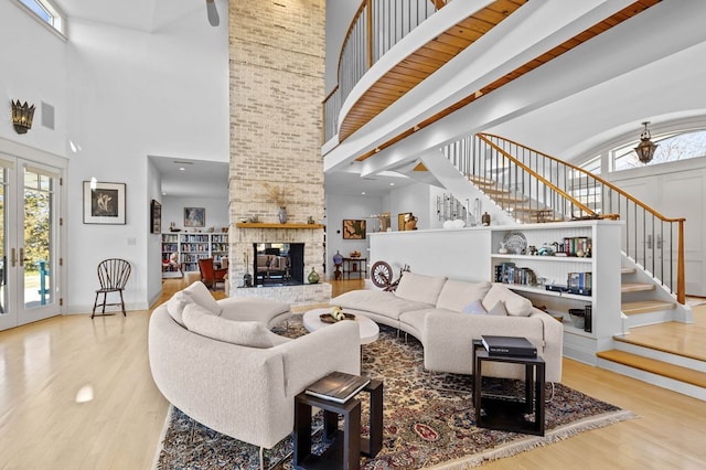 5457 Bayford Rd, Eastville, VA 23354 - living room featuring a high ceiling, stairway, wood finished floors, a multi sided fireplace, and french doors