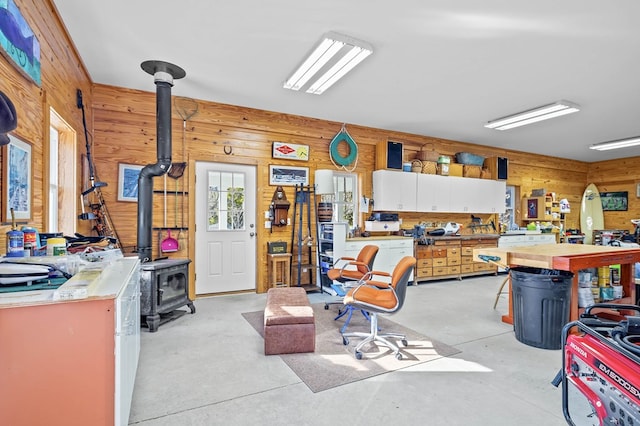 5457 Bayford Rd, Eastville, VA 23354 - misc room with a wood stove, wood walls, concrete floors, and a workshop area