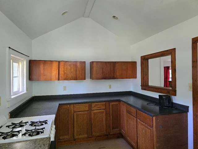 kitchen featuring vaulted ceiling and white gas stove