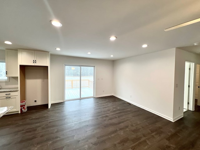 unfurnished living room with dark hardwood / wood-style flooring