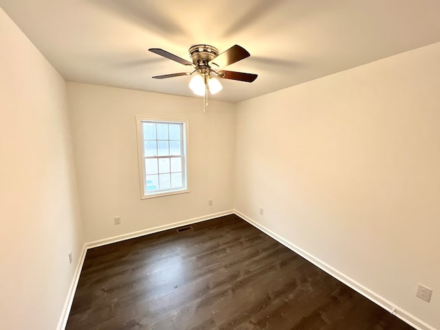 empty room with ceiling fan and dark hardwood / wood-style flooring