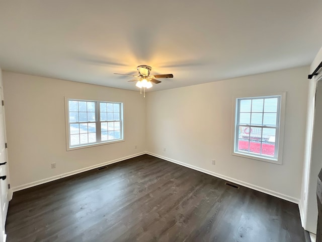 unfurnished room with ceiling fan and dark hardwood / wood-style flooring