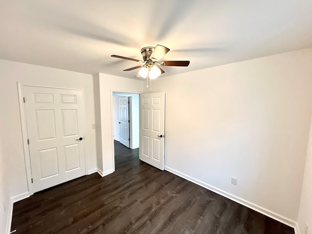 spare room with dark wood-type flooring and ceiling fan