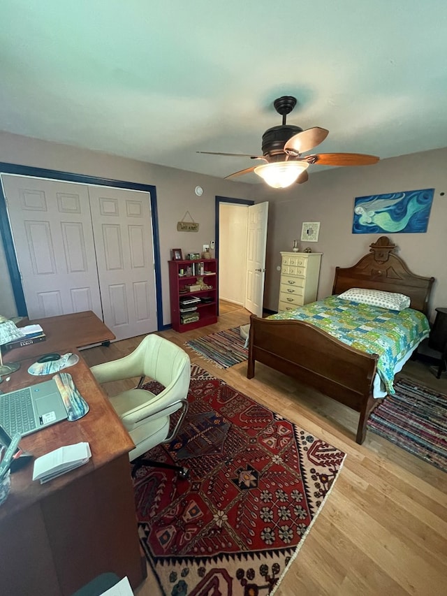 bedroom with ceiling fan, a closet, and wood-type flooring