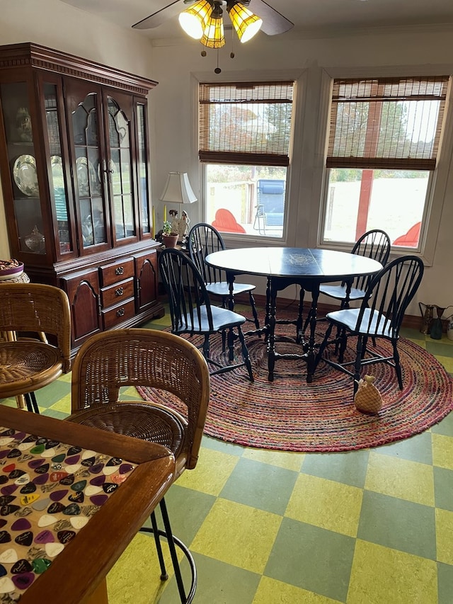 carpeted dining area with ceiling fan