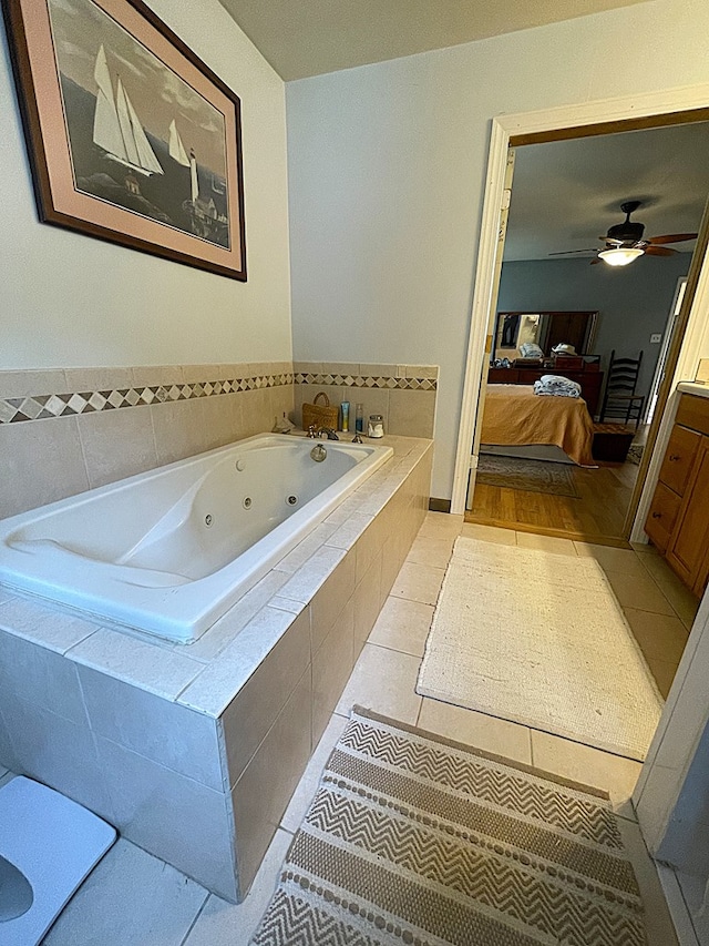 bathroom featuring tile patterned floors, tiled tub, and vanity