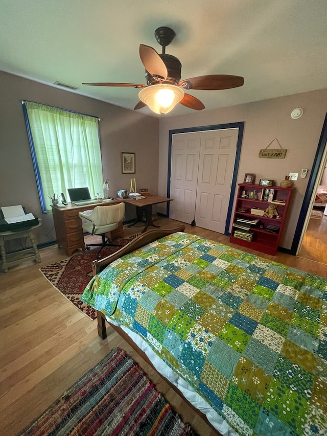 bedroom featuring ceiling fan, a closet, and hardwood / wood-style floors