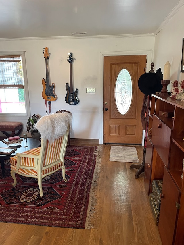 foyer entrance featuring ornamental molding and hardwood / wood-style flooring