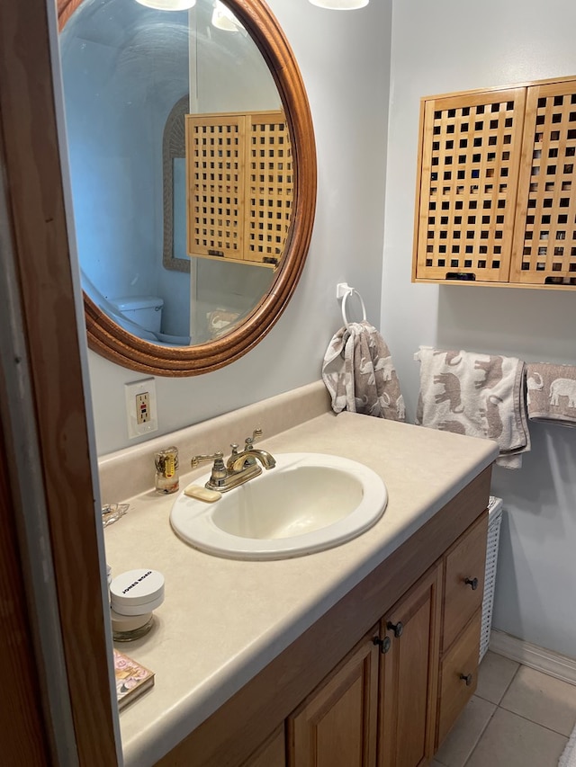 bathroom featuring toilet, vanity, and tile patterned floors