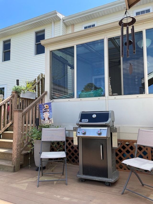 view of patio with area for grilling, a sunroom, and a wooden deck