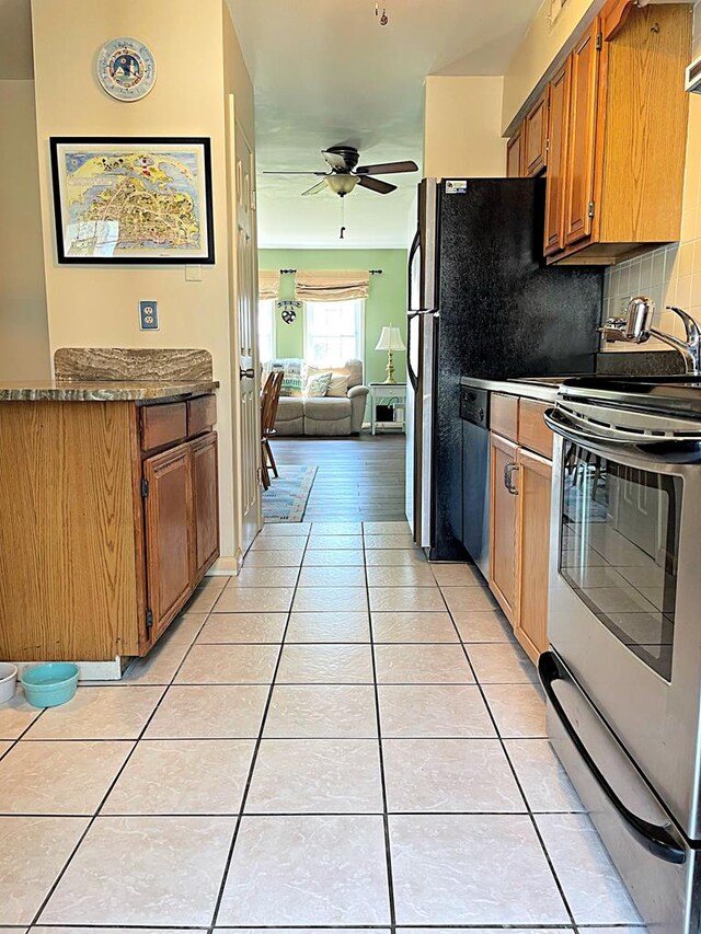 kitchen with backsplash, ceiling fan, light tile patterned floors, and stainless steel appliances