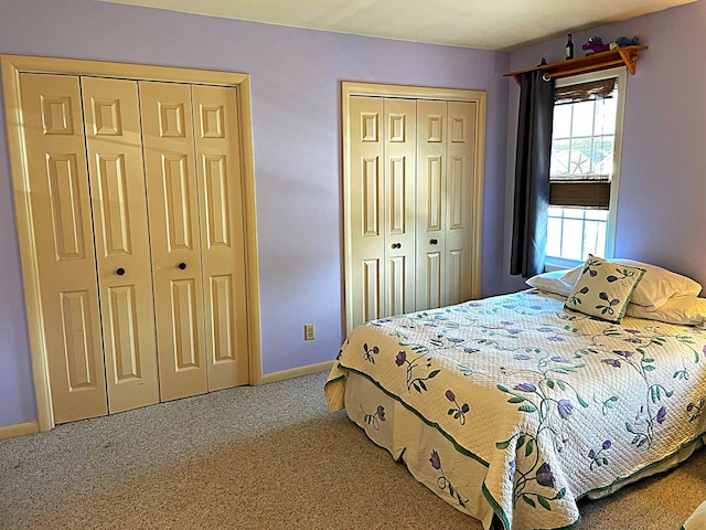 carpeted bedroom with multiple closets