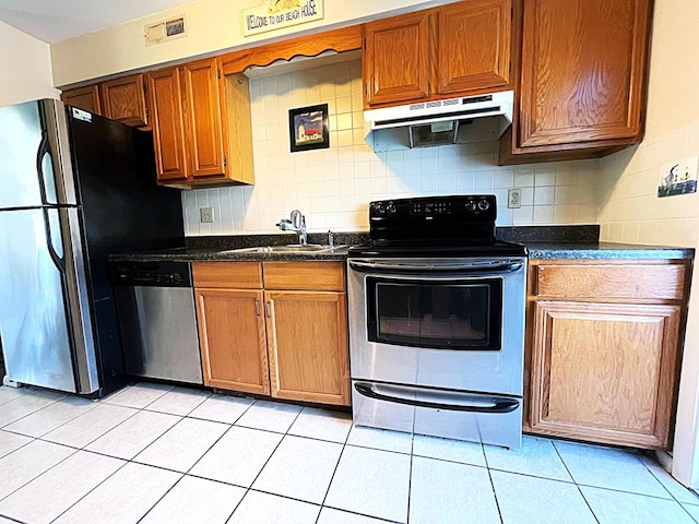 kitchen with decorative backsplash, sink, light tile patterned floors, and appliances with stainless steel finishes